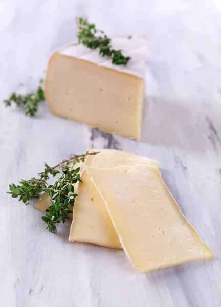 Tasty Camembert cheese with thyme, on wooden table — Stock Photo, Image