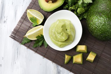 ahşap masa üzerinde kase taze guacamole