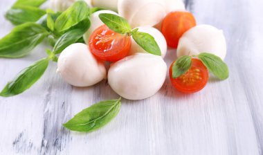 ahşap masa üstünde domates ve fesleğen ile lezzetli mozzarella peyniri