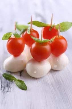 ahşap masa üstünde domates ve fesleğen ile lezzetli mozzarella peyniri