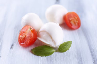 ahşap masa üstünde domates ve fesleğen ile lezzetli mozzarella peyniri