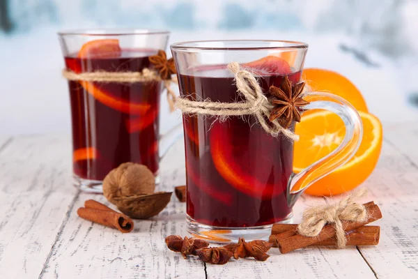 Mulled wine with oranges and spices on table on bright background — Stock Photo, Image