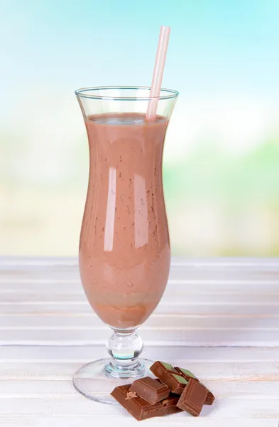 Milk shake on table on light blue background — Stock Photo, Image