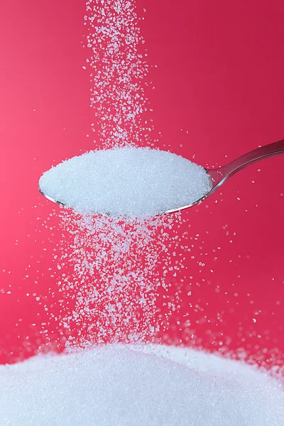 Sugar on red background — Stock Photo, Image