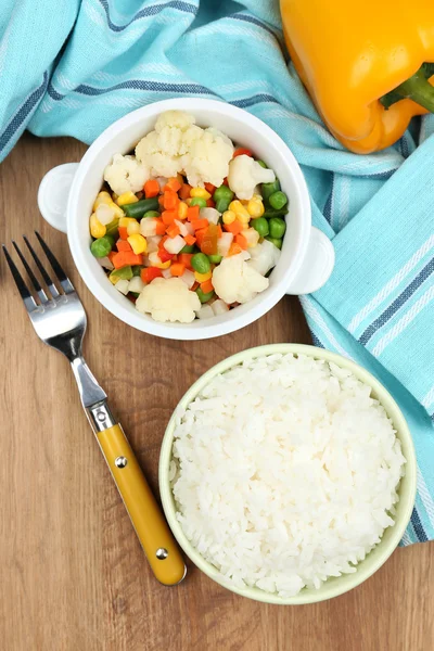 Gekookte rijst met groenten op houten tafel — Stockfoto