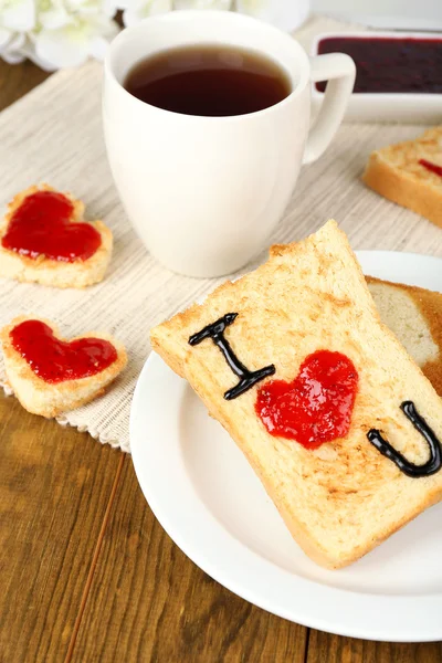 Delicioso brindis con mermelada y taza de té en primer plano de la mesa — Foto de Stock