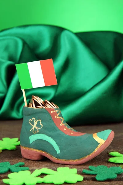 Bota de día San Patricio con monedas de oro y hojas de trébol sobre fondo verde — Foto de Stock