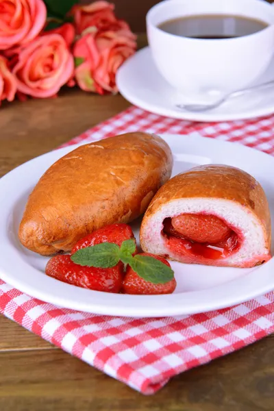 Frisch gebackenes Gebäck mit Erdbeeren auf Teller in Großaufnahme — Stockfoto
