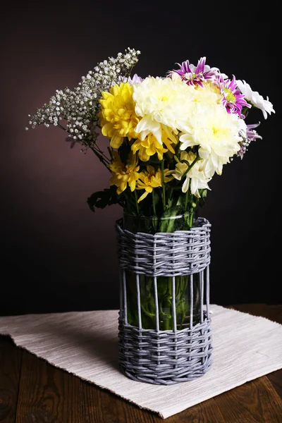 Mooie chrysant bloemen in vaas op tafel op bruine achtergrond — Stockfoto