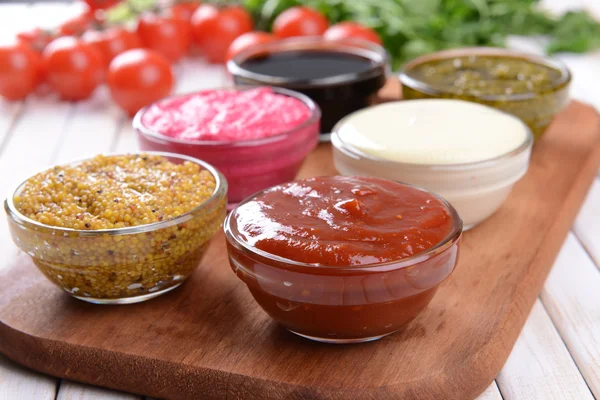 Varias salsas en la tabla de cortar en primer plano de la mesa —  Fotos de Stock