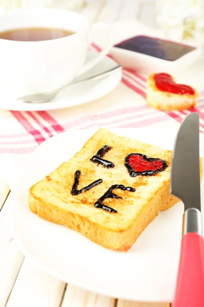 Delicious toast with jam and cup of tea on table close-up — Stock Photo, Image