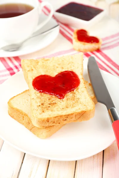 Läckra toast med sylt och kopp te på bordet närbild — Stockfoto