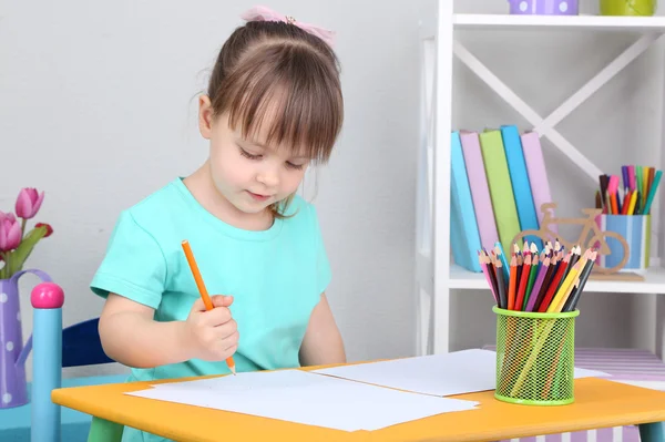 Little girl draws sitting at table in room — Stock Photo, Image