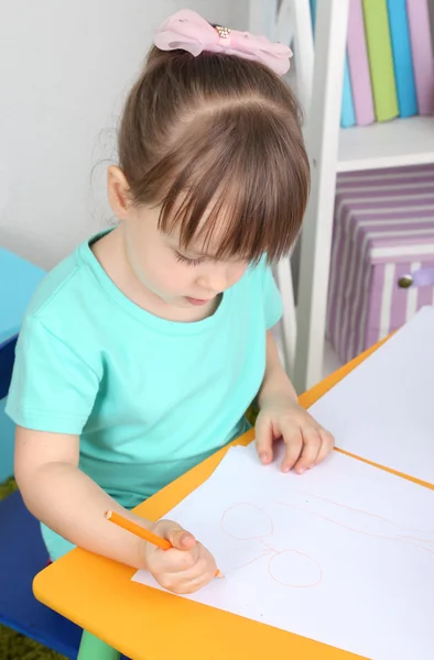 Menina desenha sentado à mesa no quarto — Fotografia de Stock