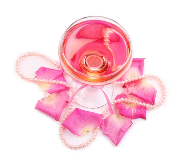 Komposisi dengan anggur berkilau merah muda di kaca dan kelopak mawar terisolasi di atas putih — Stok Foto