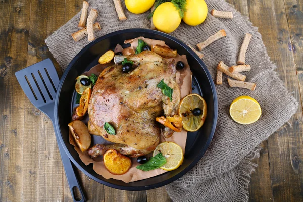 Whole roasted chicken with vegetables on pan, on wooden background — Stock Photo, Image