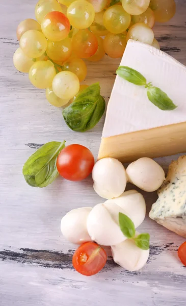 Diferentes sabrosos quesos, sobre mesa de madera — Foto de Stock