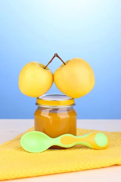 Pot de purée de bébé avec cuillère sur serviette sur fond bleu — Photo