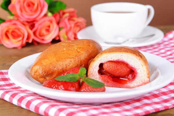 Färska bakat piroger med jordgubbar på tallriken på bordet närbild — Stockfoto