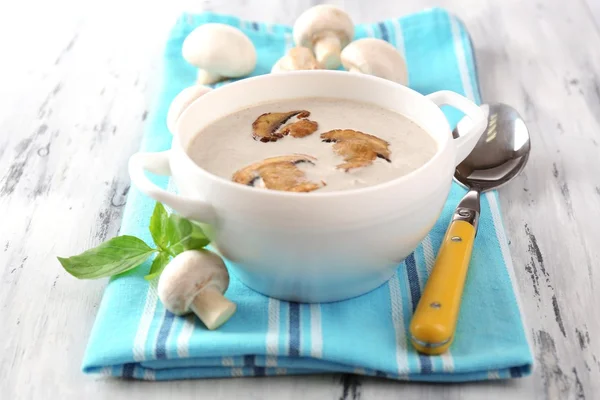 Mushroom soup in white pot, on napkin,  on wooden background — Stock Photo, Image