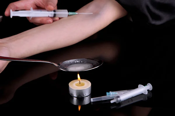 Drug addict with syringe in action on black background — Stock Photo, Image