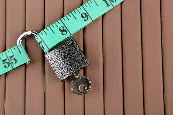 Conceptual photo of unlocking  secret of weight loss. On color wooden background — Stock Photo, Image