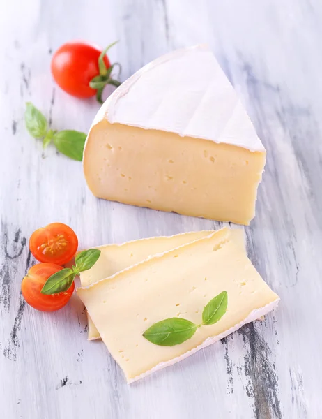 Queijo saboroso Camembert com tomate e manjericão, sobre mesa de madeira — Fotografia de Stock