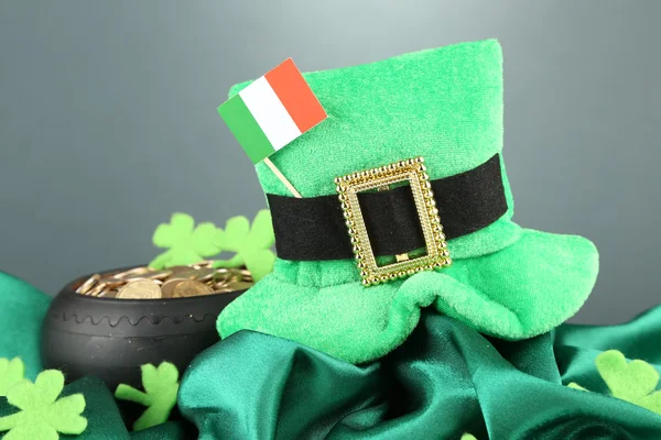 Sombrero de San Patricio, bote de monedas de oro y bandera irlandesa sobre fondo gris —  Fotos de Stock