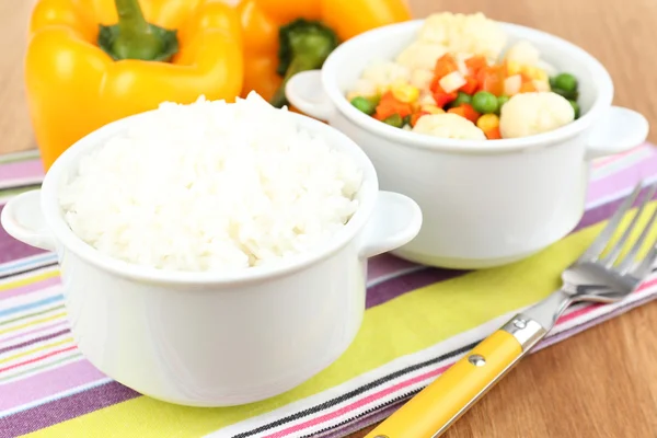 Kokt ris med grönsaker på träbord närbild — Stockfoto