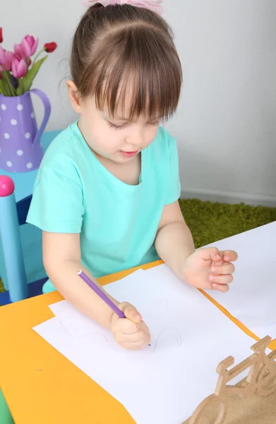 Little girl draws sitting at table in room — Stock Photo, Image