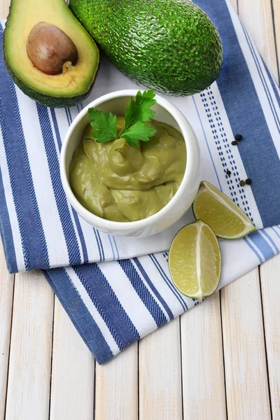 Färsk guacamole i skål på träbord — Stockfoto
