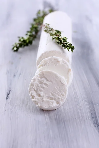 Tasty bushe cheese with thyme, on wooden table — Stock Photo, Image