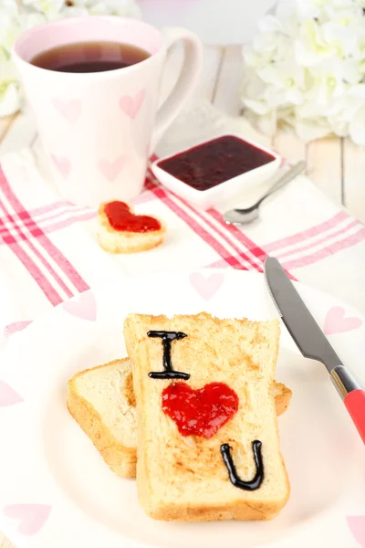 Delicious toast with jam and cup of tea on table close-up — Stock Photo, Image