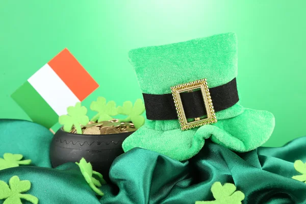 Chapéu de dia de São Patrício, pote de moedas de ouro e bandeira irlandesa em fundo verde — Fotografia de Stock