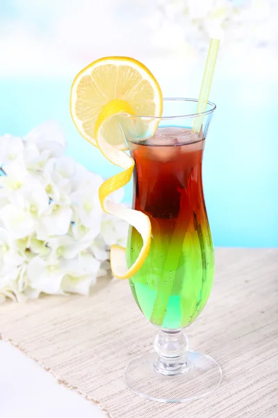 Bicchiere di cocktail sul tavolo su sfondo azzurro — Foto Stock