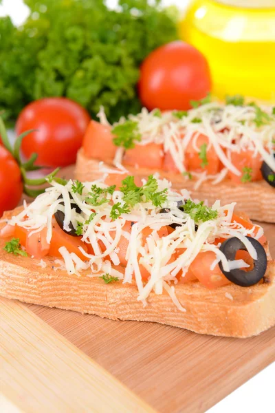 Deliciosa bruschetta con tomates en la tabla de cortar de cerca —  Fotos de Stock
