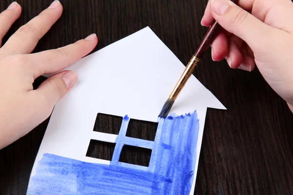 Female hand coloring paper cabin — Stock Photo, Image