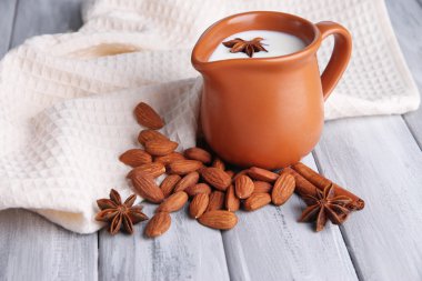 badem sütü kabı içinde kase renkli ahşap zemin üzerinde bademli