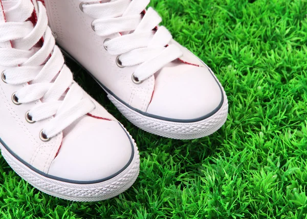 Belle scarpe da ginnastica su sfondo erba verde — Foto Stock