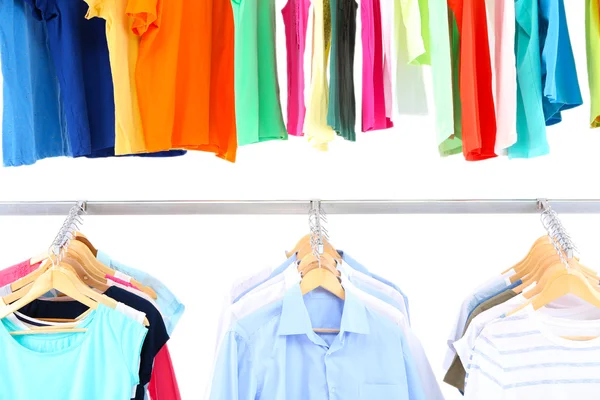 Different clothes on hangers, on gray background — Stock Photo, Image