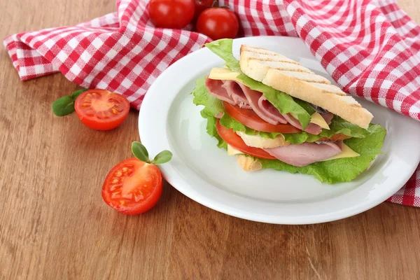 Leckeres Sandwich mit Schinken auf Holztisch — Stockfoto