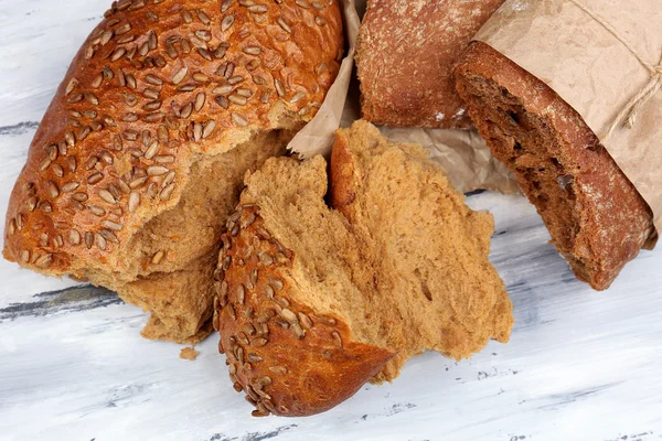 Breaking bread on wooden table — Stock Photo, Image