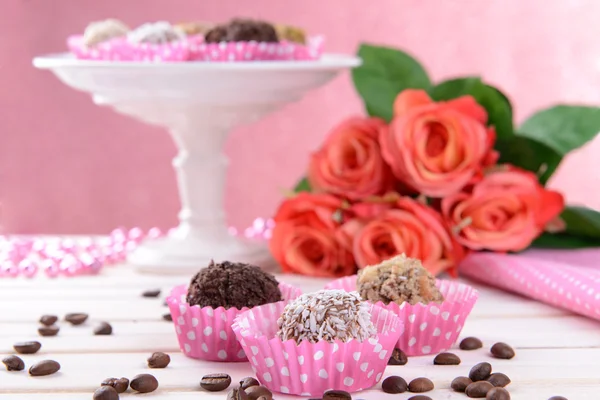 Zestaw cukierki czekoladowe na stole na różowym tle — Zdjęcie stockowe