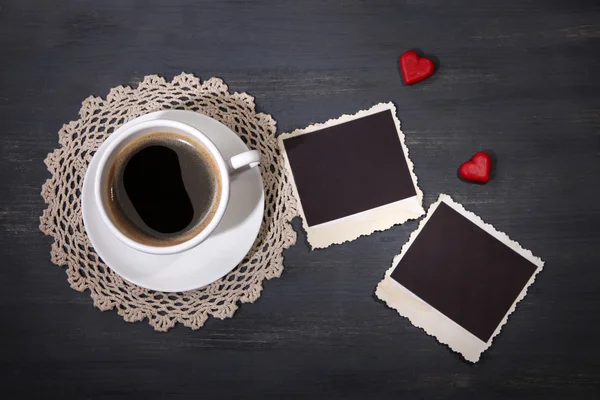 Composição com xícara de café, corações decorativos e velhas fotos em branco, em fundo de madeira — Fotografia de Stock