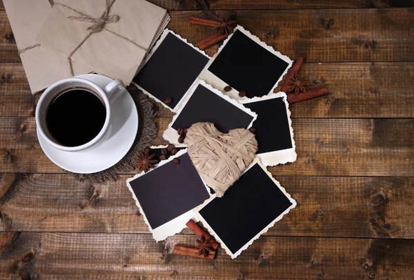 Xícara de café e velhas fotos em branco, no fundo de madeira — Fotografia de Stock