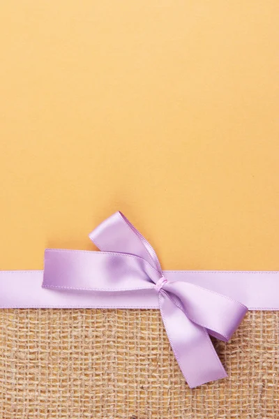Sacktuch mit Farbband und Schleife auf farbigem Papier Hintergrund — Stockfoto
