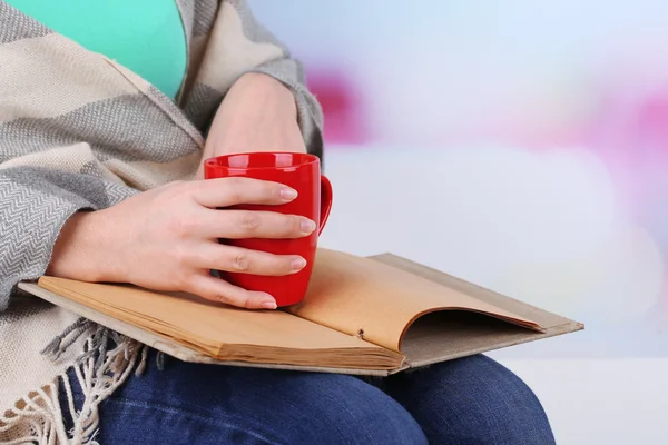 Vrouw leest boek en drinken koffie of thee, close-up — Stockfoto