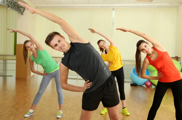 Jóvenes hermosas personas que participan en el gimnasio — Foto de Stock