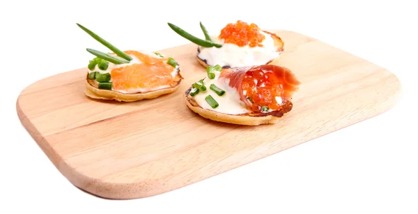 Pancakes with red caviar and salmon on wooden board, isolated on white — Stock Photo, Image