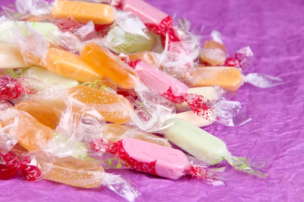 Вкусные конфеты на фиолетовом фоне — стоковое фото
